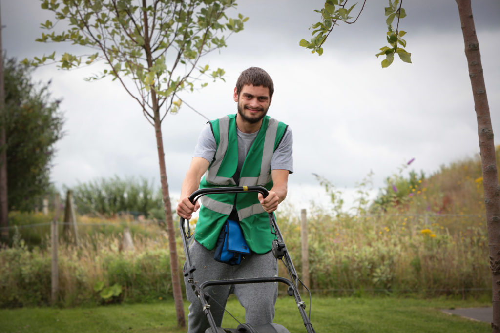 Service user Christian Edwards-Gee helps out with the mowing. 